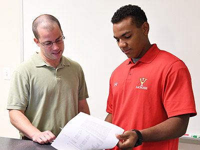 Maj. John David and Christian Helms looking at papers