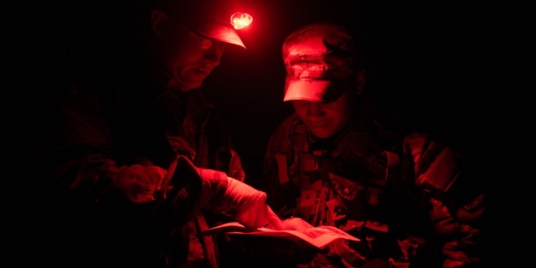 Cadets participate in field training exercises at night using red light.