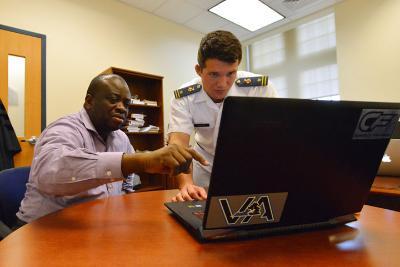 Cadet and professor look at laptop