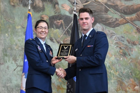 Air Force ROTC cadet receives an award from Col Scott, head of Det 880 ROTC program as he commissions into the United States Air Force.
