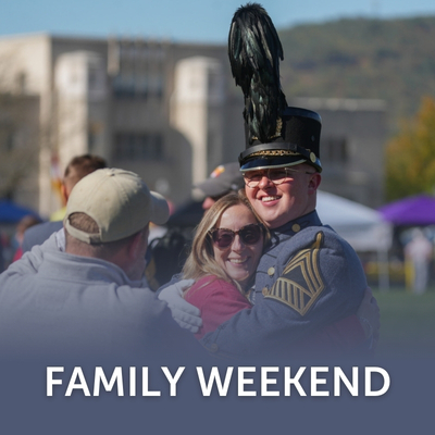 A cadet and a family member post for photos after the Family Weekend parade.