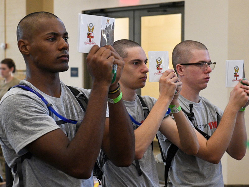 First year VMI cadets holding up and reading copies of the Rat Bible