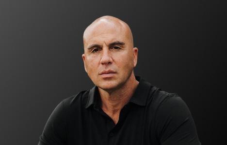 Profile headshot of Benjamin Anthony in black polo shirt