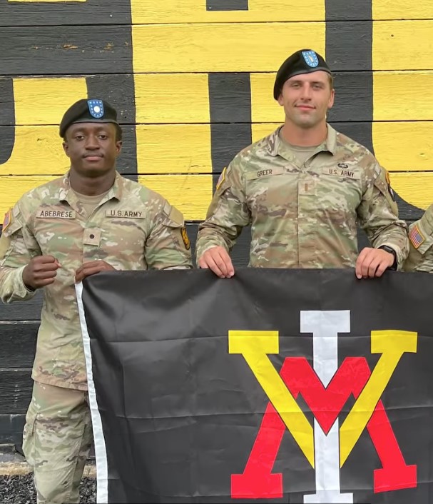 Ebenezer Abebrese poses with a VMI flag at Army training.