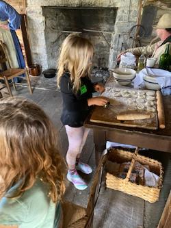 A museum guest participates in an activity in the kitchen of Bushong Farm at the Virginia Museum of the Civil War.