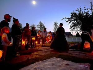 Museum visitors hear from costumed interpreters on the grounds during this evening event held in October.