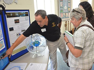 Col. Greg Topasna talks astronomy with science fair participants.