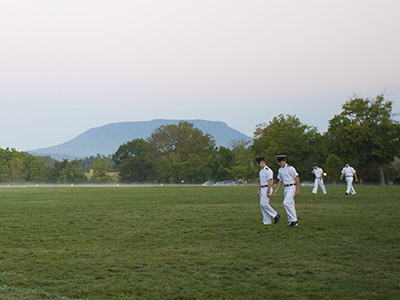 Cadets walk across the VMI Parade Ground at daybreak.