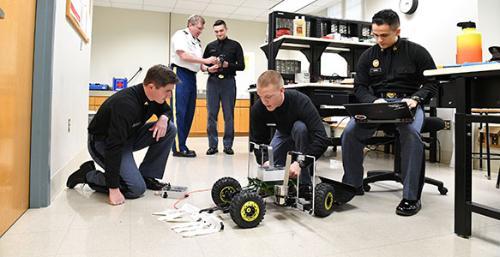 A group of cadets review a tick rover prototype