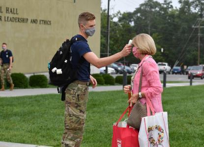 Cadet EMT Noah Kirk ’22 checks the temperature of Mary Stuart Harlow before she enters Marshall Hall on Rat Sunday, Aug. 23.—VMI Photo by Mary Price.