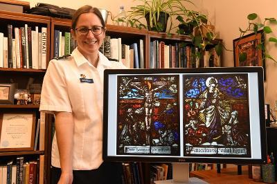 Lt. Col. Catharine Ingersoll poses with photograph of the two 16th century stained-glass panels
