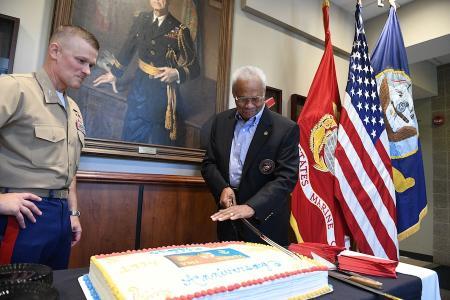 Col. Travis Homiak ’95 looks on as Sgt. Maj. Alvin Hockaday uses a saber to cut the anniversary cake.
