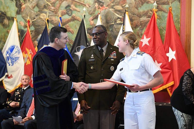 A cadet and professor share the stage with Maj. Gen. Cedric T. Wins '85, VMI superintendent while receiving their awards.
