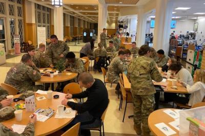 Cadets, faculty, staff, and community members gather in the post exchange to create handmade holiday cards for senior citizens.