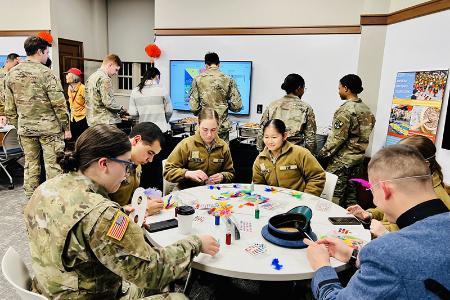 Students (cadets) at VMI, a military college, design crafts during a Global Festivities event on campus (post).