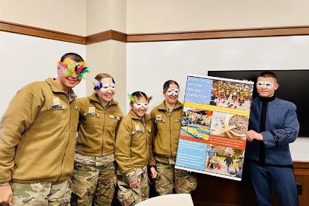 Students (cadets) at VMI, a military college, hold a posted and model carnival masks during  Global Festivities event on campus (post).