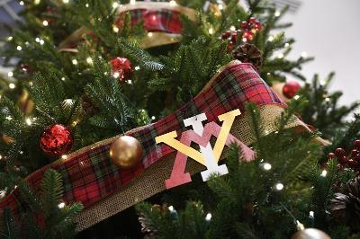 VMI ornaments and tartan garland on an evergreen tree.