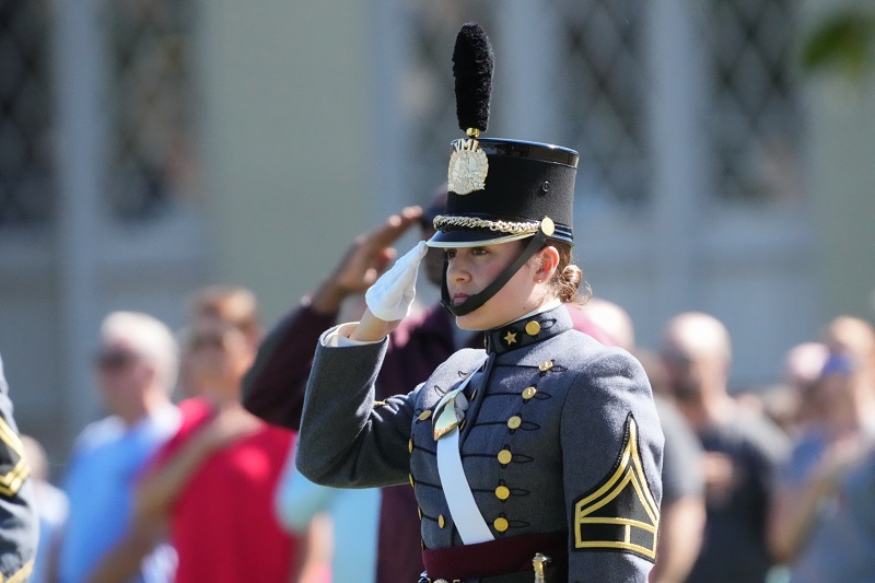 A female student (cadet) at VMI salutes during a parade on campus, which is known as post at this military college in Virginia.