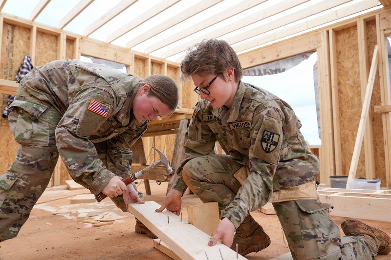 Two students at VMI, known as cadets, work together on a community service project, building homes in the local community.