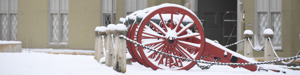 Cannon outside barracks are covered in snow.