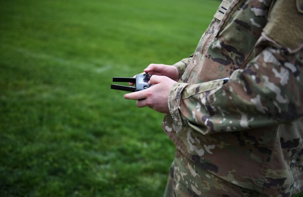 A cadet holds the controls to a drone in their hands.