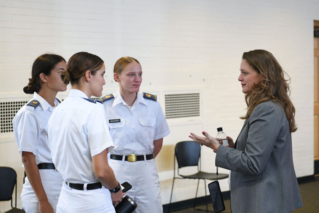 Female alumnus speaks with femal cadets.
