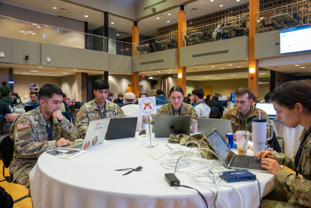 VMI cadet in uniform work on their laptops.