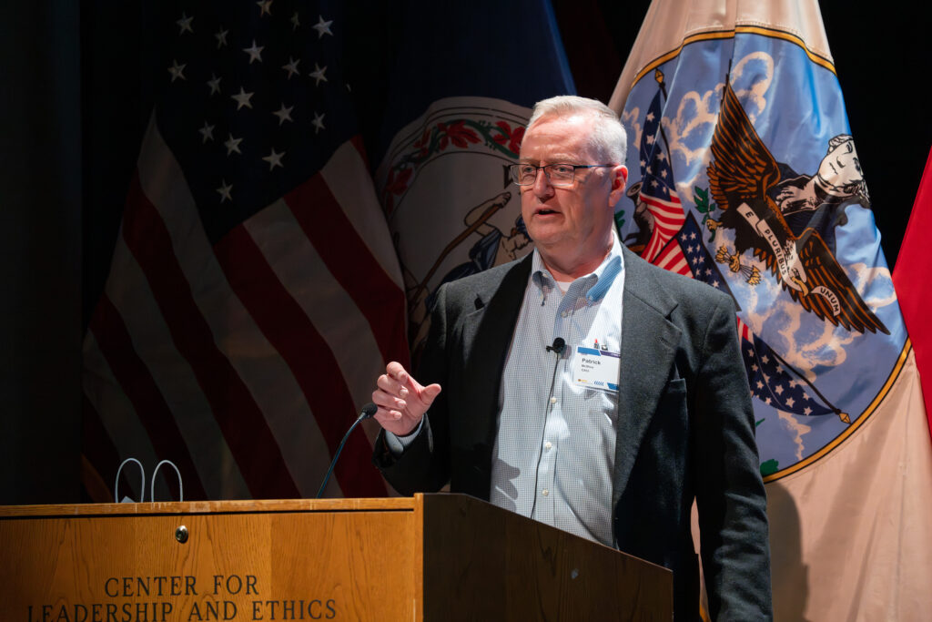 McShea stands at a podium on the stage.