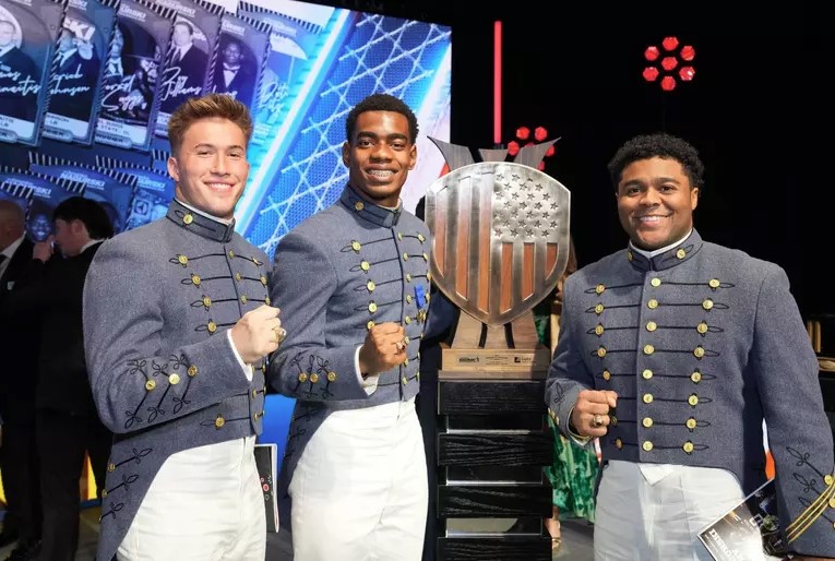 Crump and teammates pose with his award, showing off their class rings.