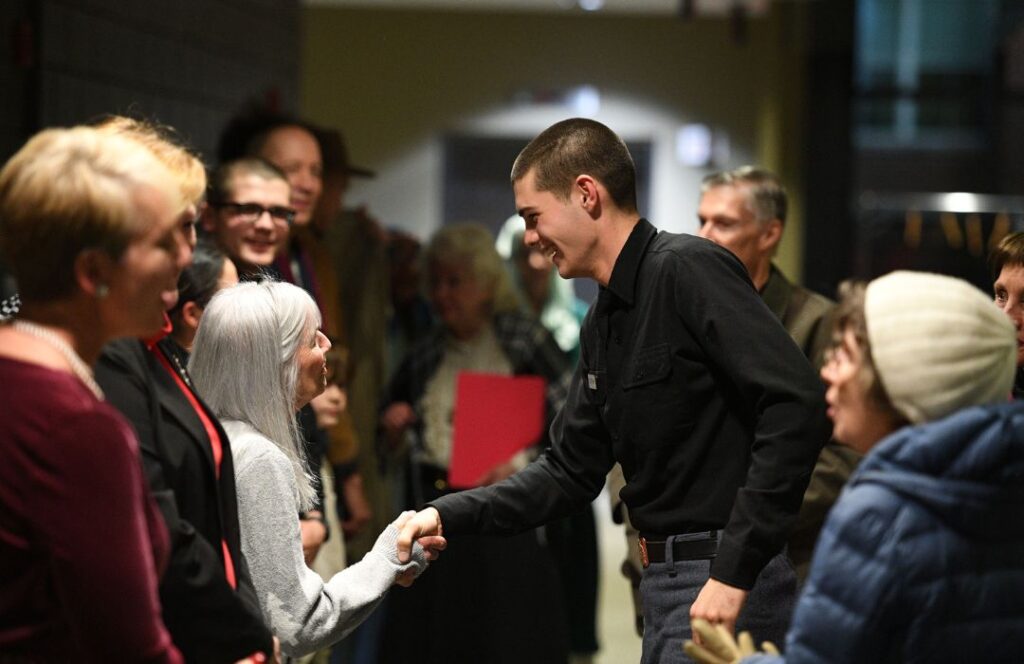 A cadet talks with audience members after a theater performance.