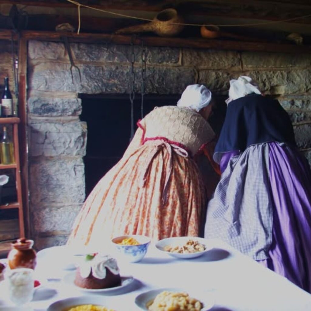 Two interpreters work at a fireplace and the kitchen table is adorned with festive treats.