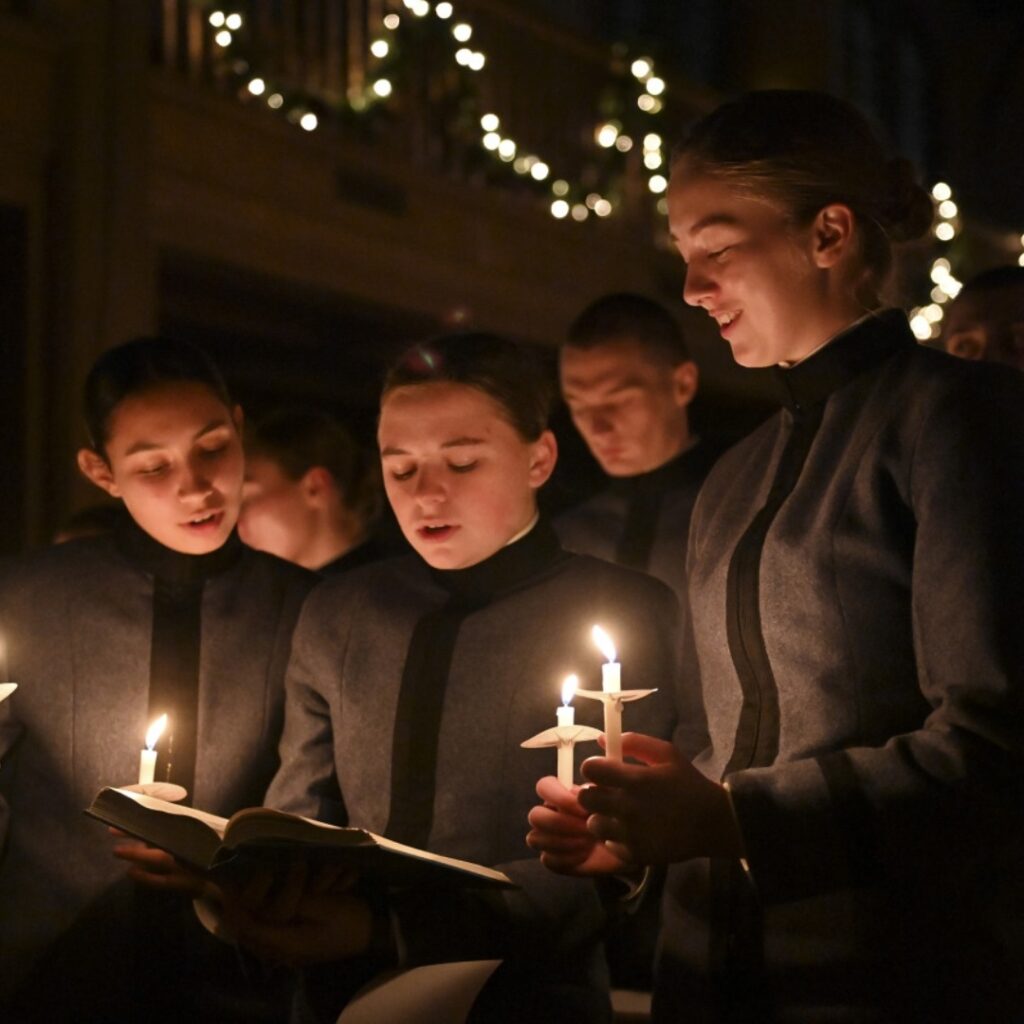 Cadets sing and hold candles in Memorial Hall.