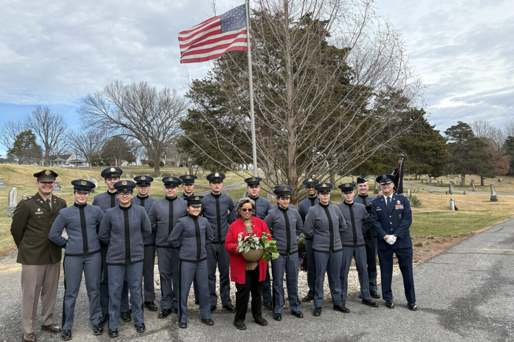 Cadets and others pose for a photo with holiday wreath.