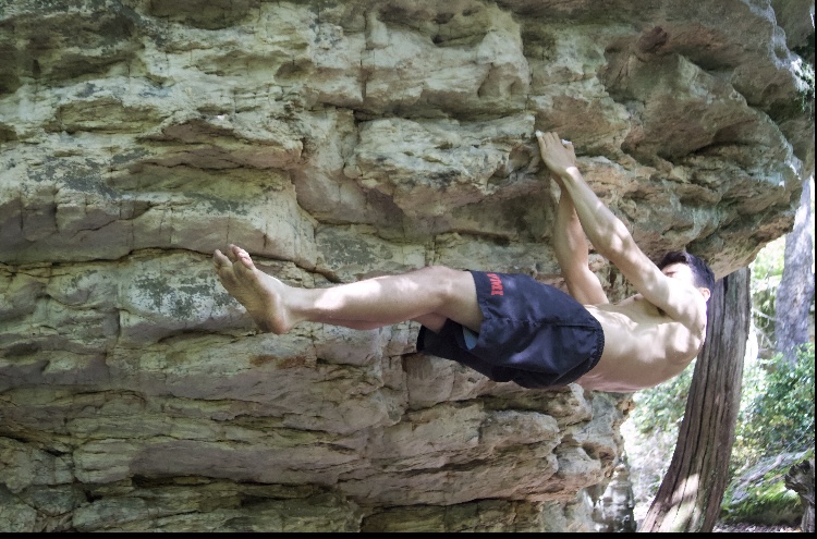 A guy grappling on rocks as a part of the rock climbing club at VMI.