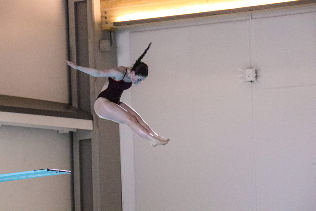 A diver mid-dive off the diving board.