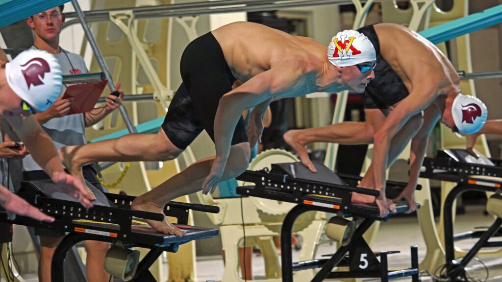 Matthew Picard diving into the pool during a Virginia Military Institute swim meet.