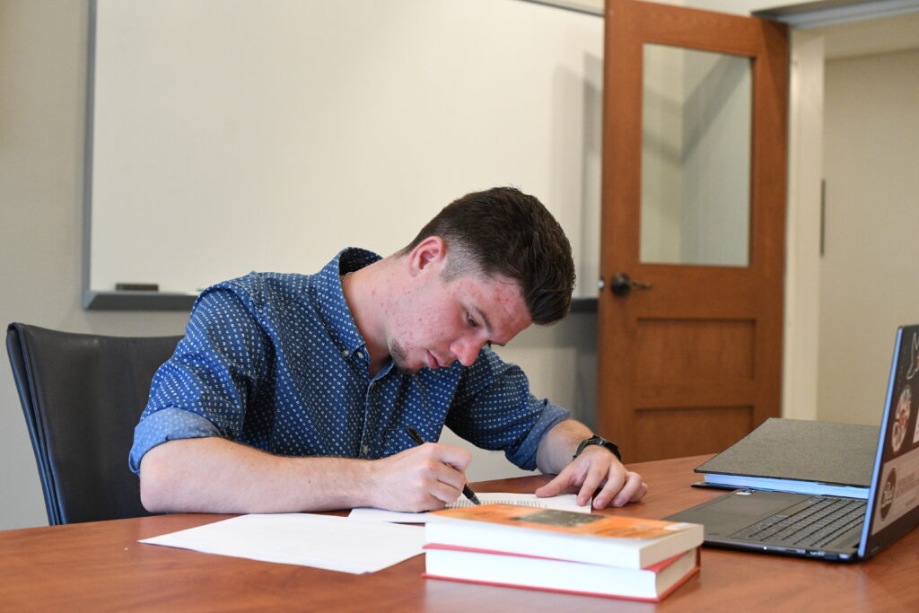 A student studying in front of a computer in a classroom.