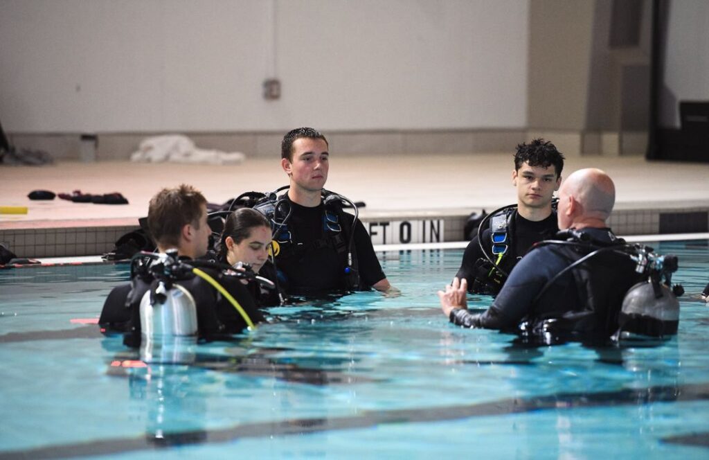 Cadets await instruction with scuba gear in the pool.