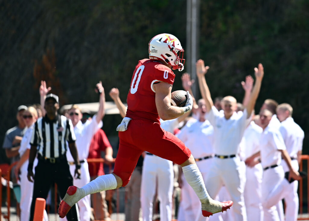 Grant Swinehart with a football in hand while running down the field.