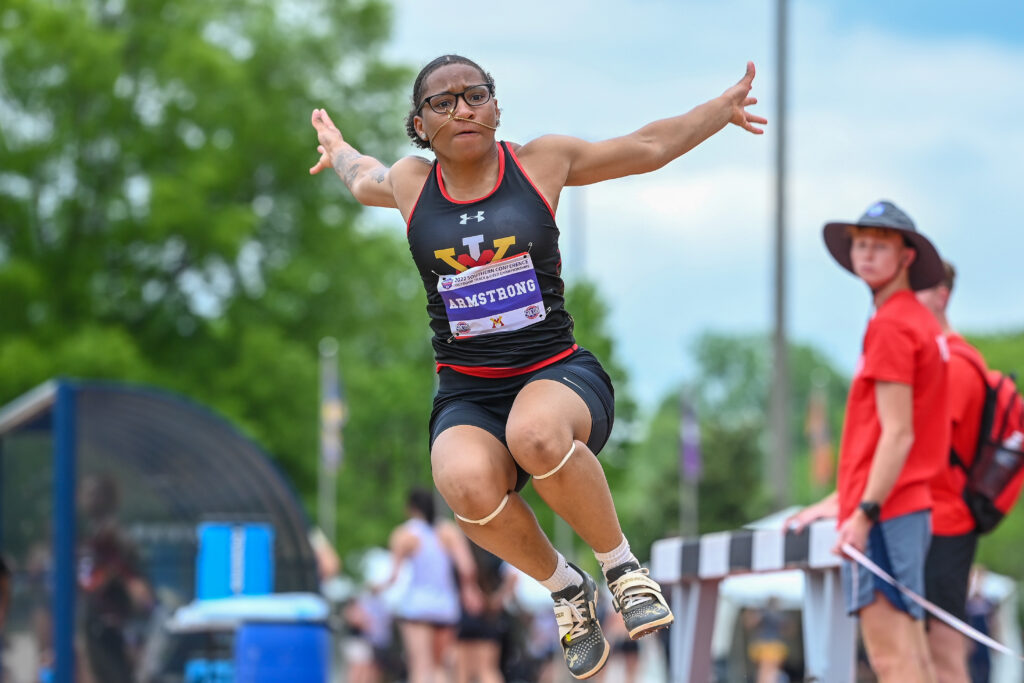 Eleyah Armstong jumping at a track and field event for Virginia Military Institute. 