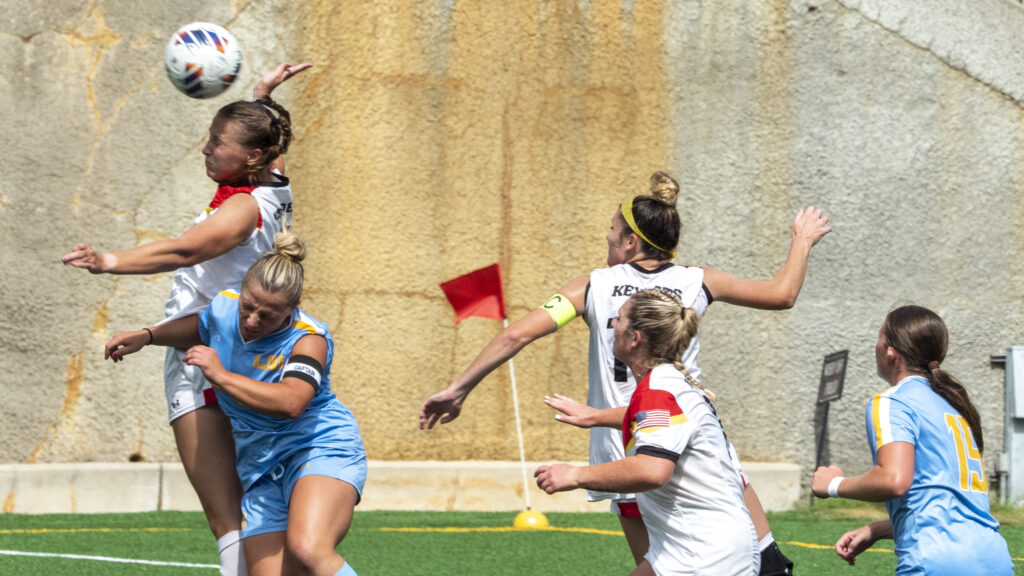 Audrey Davis hits the soccer ball on the field.