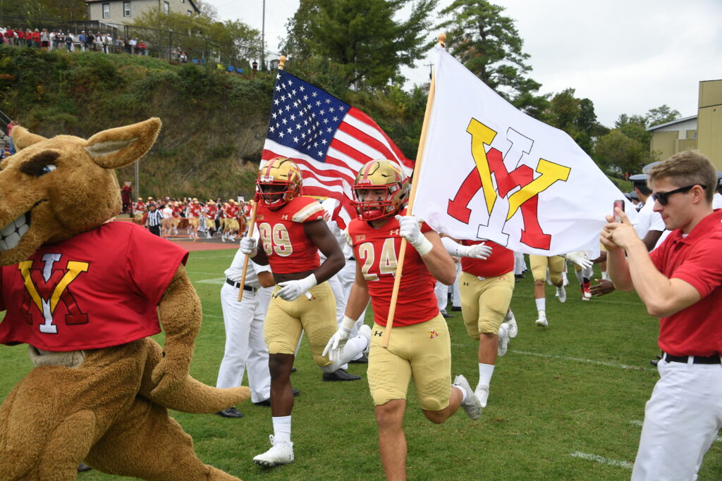 The football teams runs onto the field.