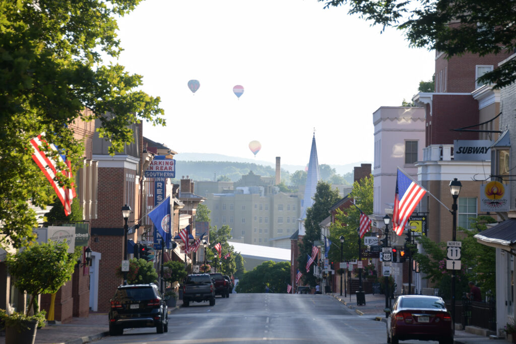 Hot air balloons can be seen above Main Street in Lexington where shops line the street.