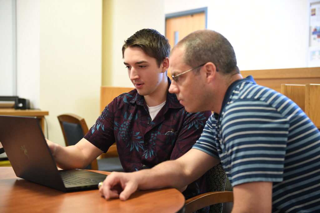 A VMI cadet and his project advisor work at a laptop.