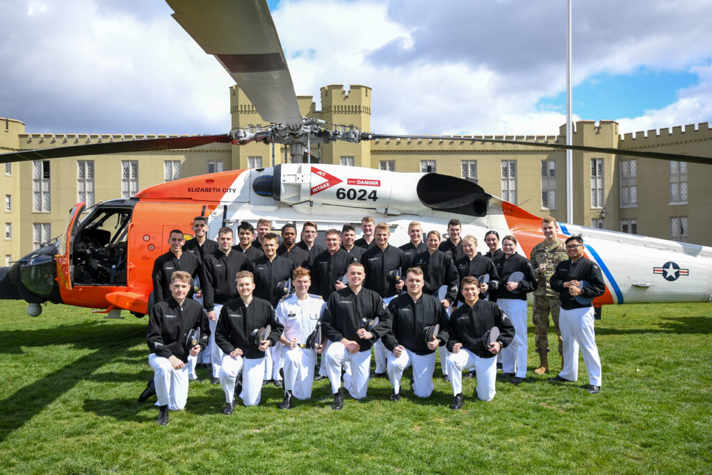 Coast Guard AUP cadets in front of a helicopter on post.