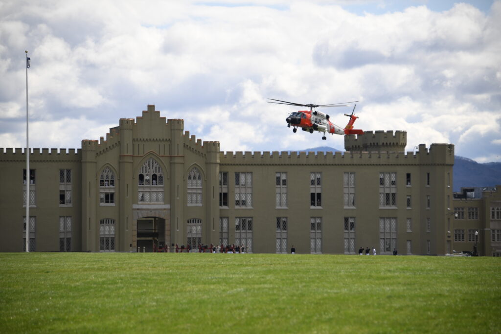A helicopter flies over barracks.