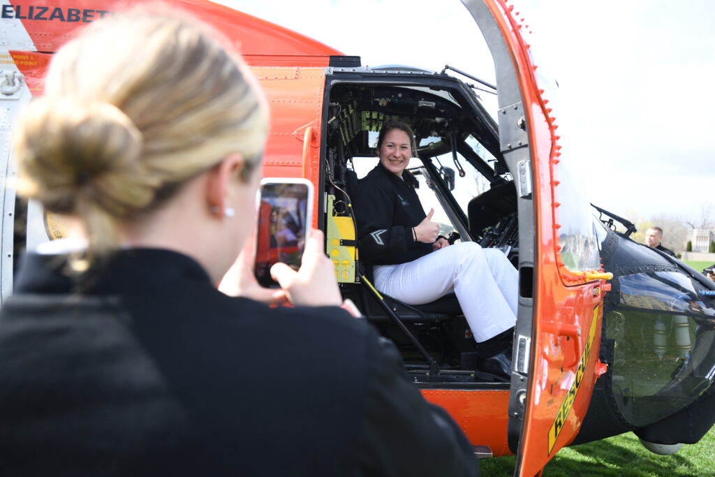 A cadet snaps a photo of another cadet inside a helicopter.