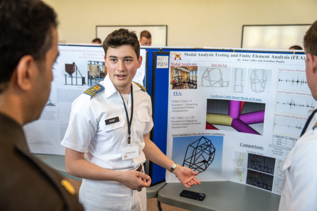 A college students present his research via poster during a symposium.