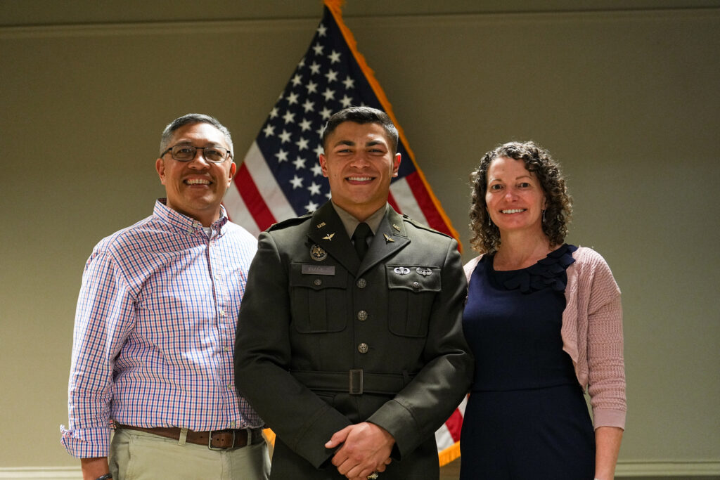 A newly commissioned Army officer poses for a photo with his parents.