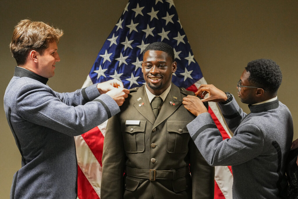 A new 2nd Lieutenant has his Brother Rats affix his pins.